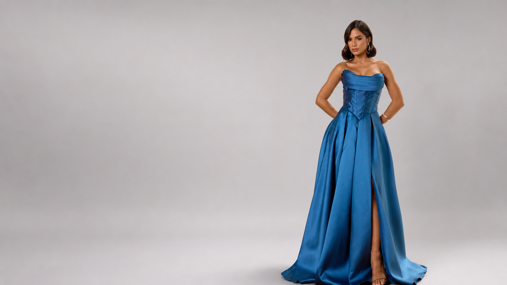 Modelo com vestido azul longo em estúdio de fundo cinza